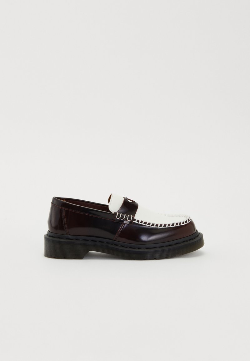 Mocassin en cuir bicolore marron foncé et blanc avec des détails de couture et une épaisse semelle noire, présenté en profil latéral sur un fond blanc.