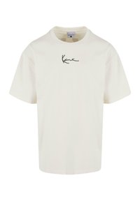 Krämfärgad t-shirt med rund halsringning och korta ärmar. Har en svart signaturlogotyp på bröstet. Slätt bomullstyg.
