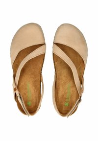 Scarpe in pelle beige con cinghie incrociate, punta arrotondata e soletta in morbido camoscio. Suola texture per aderenza. Marchio visibile sulla soletta.