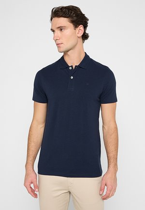 Mornarska polo majica s kratkimi rokavi, s plaketko na tri gumbe in diskretno vezenim logotipom. Gladek bombažni material z oprijetim dizajnom.