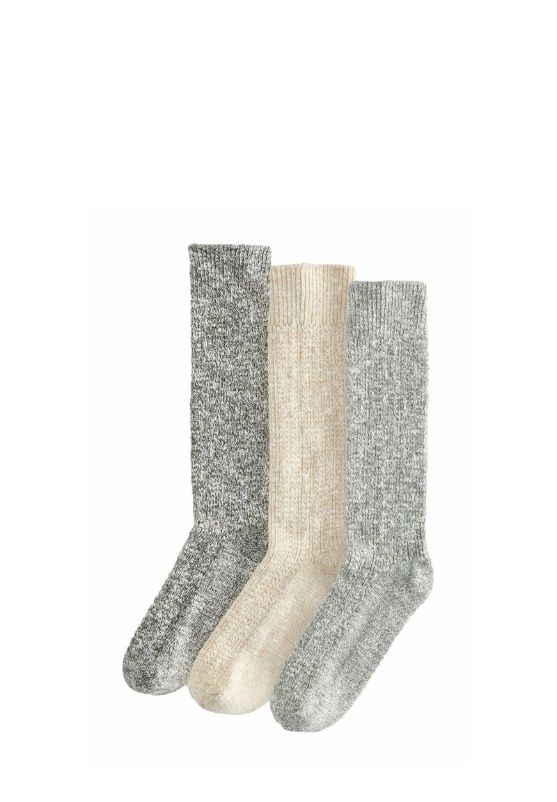Tre par af strikstrømper til midten af læggen i meleret grå, creme og lys grå farver, arrangeret side om side på en hvid baggrund.