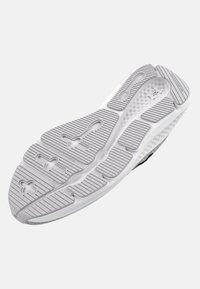 Semelle de chaussure de sport noire et grise en caoutchouc texturé, avec un motif de grip et des découpes pour plus de flexibilité. Accents blancs sur les bords.