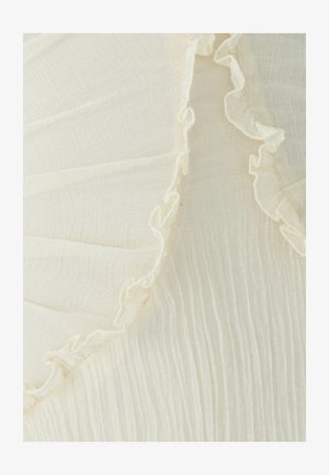 Lichtgewicht, gekreukt stof in off-white, met een delicate ruchestrim langs de rand. Zachte textuur met subtiele horizontale lijnen.