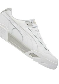 Scarpa sportiva bianca con tomaia in pelle, colletto imbottito e suola in gomma. Presenta dettagli grigi e un pannello laterale testurizzato per una migliore presa.
