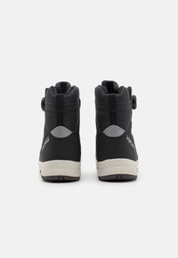 Bottes noires imperméables avec une surface texturée, design à cheville haute, fermeture réglable et accents gris contrastants. Semelle en caoutchouc.