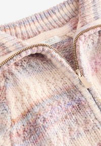 Strickjacke in Pastellfarben mit einem strukturierten Muster. Verfügt über einen silbernen Reißverschluss und ein Etikett innen. Weicher, warmer Wollmischstoff.