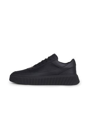 Zwarte lage sneaker met dikke geribbelde zool, bovenwerk van mesh en leer en zwarte veters, zijaanzicht op witte achtergrond.