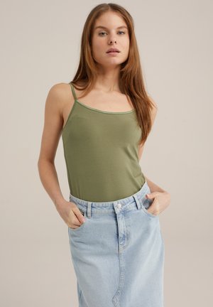 Green fitted tank top with thin straps, paired with light blue denim skirt. Smooth texture, minimal design, and no visible patterns or accents.