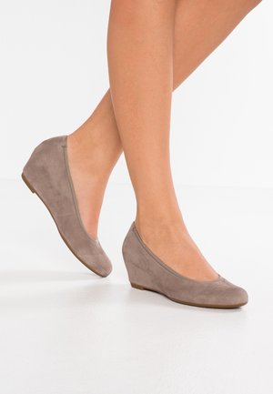 Taupe suede wedge shoes with a rounded toe, minimalistic design, and a smooth texture. Low heel provides stability.