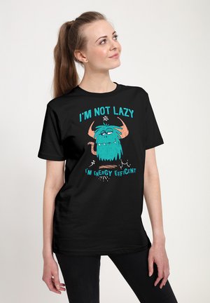Black t-shirt featuring a colorful cartoon monster with blue fur and orange horns. Text reads “I'M NOT LAZY, I’M ENERGY EFFICIENT.”