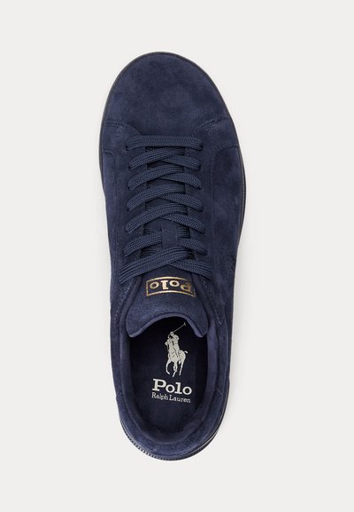 Mörkblå mockasneaker med texturerade skosnören, Polo Ralph Lauren-logotyp på innersulan och en guldfärgad "Polo"-etikett på tungan, sedd uppifrån.