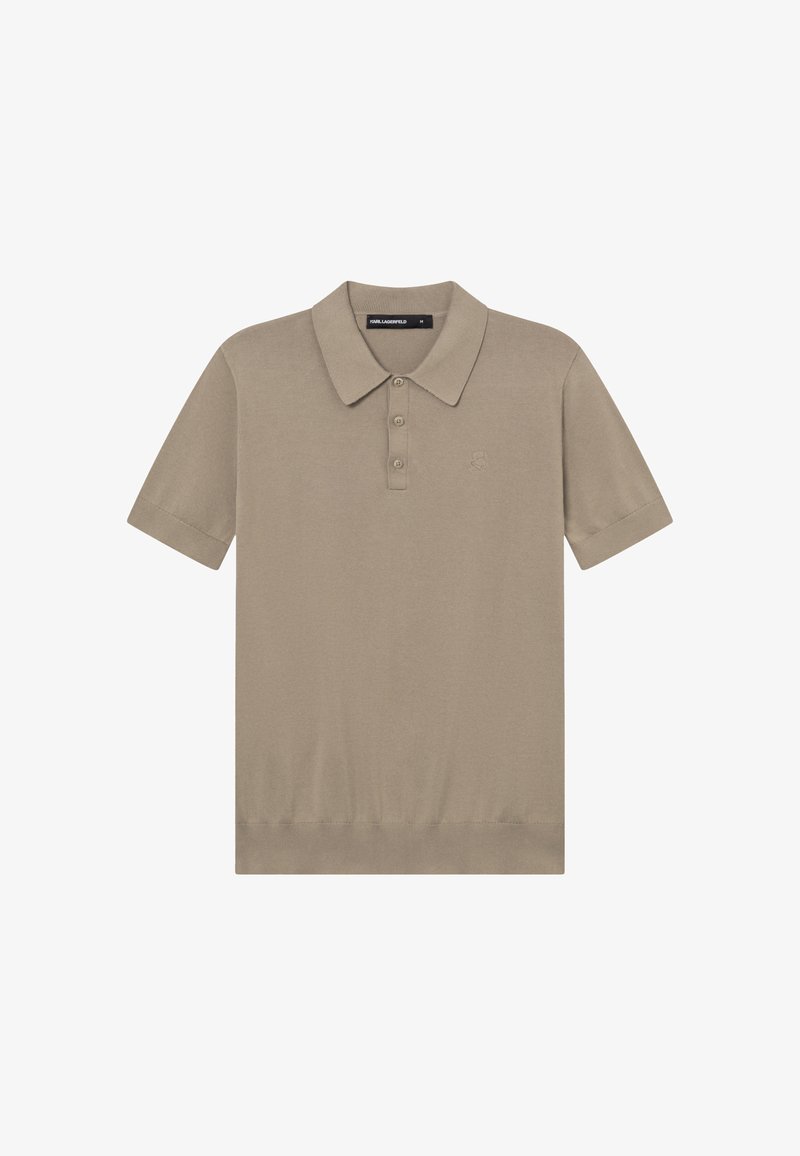 Polo beige à manches courtes avec trois boutons, col et logo brodé discret sur le côté gauche de la poitrine.