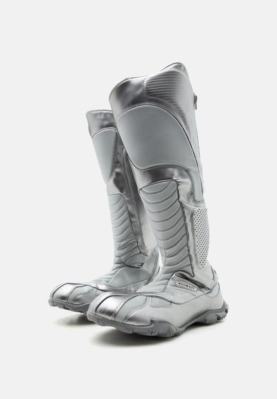 Ψηλά γκρι μπότες μοτοσικλέτας με ενισχυμένη επένδυση και υφασμένες σόλες, σχεδιασμένες για προστασία και ανθεκτικότητα.