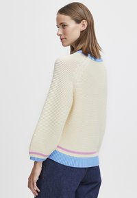 Strickpullover in Creme mit blauen, rosa und hellblauen Akzenten. Lockerer Schnitt, gerippte cuffs und Saum, strukturierter Stoff und runder Ausschnitt.
