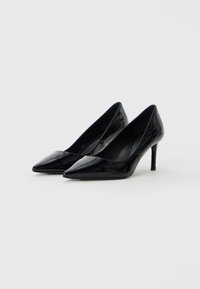 Sorte lakkledds høye hæler med spiss tå og slank stilettheel, med et elegant design og blank overflatestruktur.
