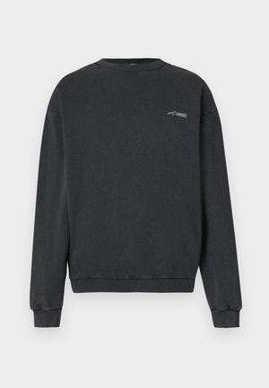 Czarna bluza crewneck z długimi rękawami i małym białym logo "ARKK" na górnej lewej stronie klatki piersiowej, z prążkowanymi mankietami i krawędzią.