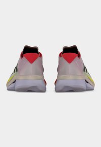 Letvægts sportssko med en overdel af mesh i lyserød, med sorte detaljer, en rød hæl og en farverig mellemsål. Tekstureret gummiydersål.