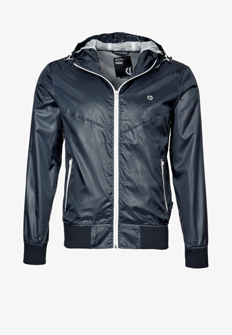 Veste légère à capuche bleu marine avec fermeture éclair blanche et poches zippées, poignets et ourlet côtelés, et logo discret sur la poitrine.