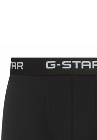 Schwarze Boxer-Brief mit einem strukturierten Bund, der das G-Star-Logo in kontrastierendem Hellgrau zeigt. Glattes Material und enganliegendes Design.
