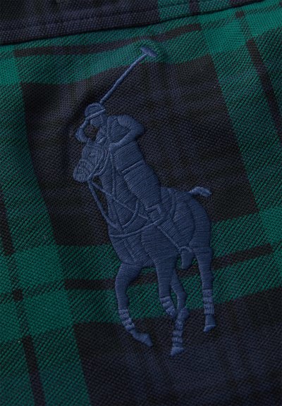 Wyszywany motyw gracza polo na koniu trzymającego uniesioną pałkę, wykonany ciemnoniebieską nicią na zielonej i granatowej tkaninie w kratę.