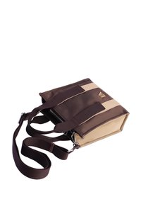 Pequeño bolso rectangular bicolor en marrón y beige, con correa ajustable y logotipo en tono dorado en la parte frontal.