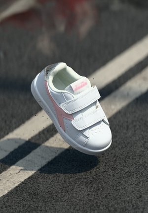 Chaussure de sport blanche avec des accents roses et des détails texturés gris, dotée de deux sangles réglables en velcro et de perforations pour la respirabilité.