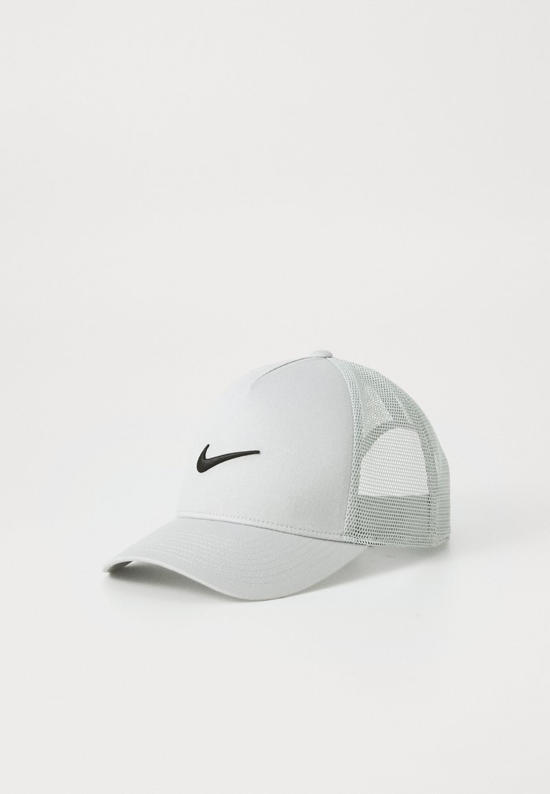 Szara siatkowa czapka z solidnym szarym przednim panelem i czarnym logo Nike. Posiada zakrzywiony daszek oraz oddychające siatkowe boki.