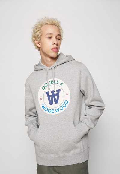 Grå hoodie lavet af blødt stof, der har et cirkulært logo med "DOUBLE A" og "WOOD WOOD" i blå og grøn, fremhævet med snore.