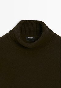Dunkelolivgrüner, gerippter Kaschmirpullover mit hohem Rollkragen, der das innere Massimo Dutti-Label zeigt.
