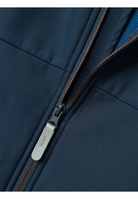 Chaqueta navy con una textura suave, cierre de cremallera ajustable con un tirador plateado y costuras en naranja contrastante.