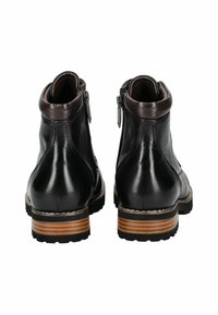Stivaletti neri in pelle con accenti marroni, zip laterale, tacco in legno impilato e suola in gomma texturizzata. Presentano una finitura liscia e lucida.