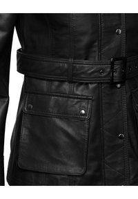 Czarna skórzana kurtka z przeszytymi panelami, pasek z czarną klamrą oraz kieszenie na klapki zabezpieczone metalowymi napami.