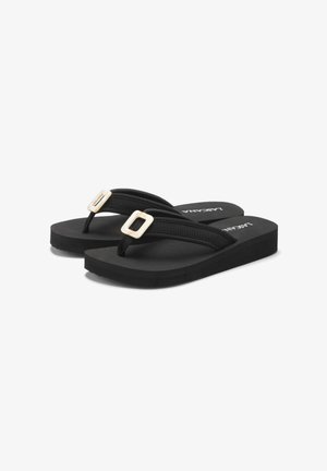 Schwarze Flip-Flops mit dickem Gummisohle, strukturierten Riemen und dekorativen Schnallen. Minimalistisches Design mit modernen Akzenten und einer bequemen Passform.