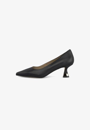 Zapato de tacón alto de cuero negro con punta afilada y un tacón geométrico único, con un acento dorado en la base. Textura suave en todo.