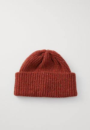 Rust-colored knitted wool beanie with folded cuff, laid flat on a white surface.