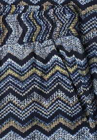 Stoff mit Zickzack-Chevron-Muster in Marineblau, Beige, Weiß und Hellblau, mit gerafftem Gummizug am oberen Rand.