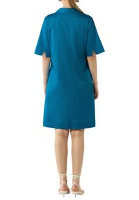 Teal Kleid aus schimmerndem Stoff mit kurzen Ärmeln, Kragen und knielangem Saum. Glattes Material, minimalistische Details, kombiniert mit Riemchenheels.