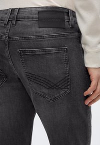 Τα γκρι τζιν από τζιν υλικό διαθέτουν κομψό σχεδιασμό με διακριτική ξεθώριασμα, δερμάτινη ετικέτα του brand και χαρακτηριστική ραφή στις πίσω τσέπες.