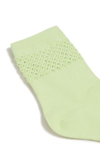 Hellgrünes Knöchelsocke mit einem strukturierten, gestrickten oberen Teil und glattem Körper, aus einem weichen Material für zusätzlichen Komfort.