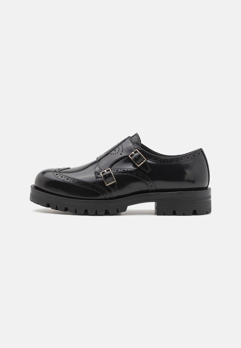 Chaussure brogue en cuir noir avec double boucle, détails perforés, bout arrondi et semelle robuste pour une meilleure adhérence et durabilité.