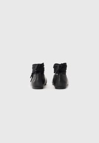 Sorte lær ankelsko med en myk, samlet stoffkrage, med rund tå og minimalistisk design.