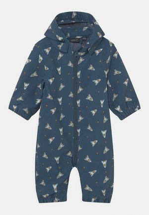 Mørkeblå regndragt med raket- og stjernemønster, lynlås foran og korte ærmer. Fremstillet af vandafvisende materiale med letvægtsdesign.