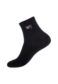 Chaussette noire de cheville en matériau lisse, avec un patch logo blanc, rouge et bleu. Conçue pour un ajustement serré autour de la cheville.