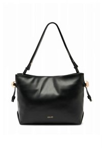 Sac à main en cuir noir à la texture lisse, avec des accents dorés et des bretelles réglables. Présente un logo sur le devant et un design spacieux.