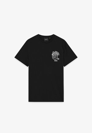 Black cotton t-shirt featuring a white graphic of a lion’s head wearing a hat, with "HIGHLANDER" and "1874" printed underneath.