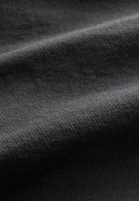 Black textured fabric with a subtle grid pattern, smooth surface, and draped appearance showcasing folds and light shadows.