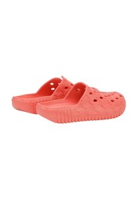 Zoccoli color corallo realizzati in plastica leggera e strutturata. Presentano motivi a onda ritagliati e una suola spessa e rigata per maggiore stabilità.