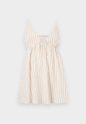 Robe blanche sans manches avec fines rayures verticales marron, nouée devant, avec fines bretelles, présentée sur un fond uni.