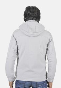 Veste grise claire à fermeture éclair avec capuche, présentant une texture lisse, des poignets élastiques et une coupe décontractée, vue de dos.