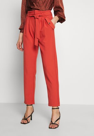 Rode op maat gemaakte broek met hoge taille, voorzien van een ceintuur, zijzakken en een ontspannen pasvorm. De stof oogt glad en gestructureerd.